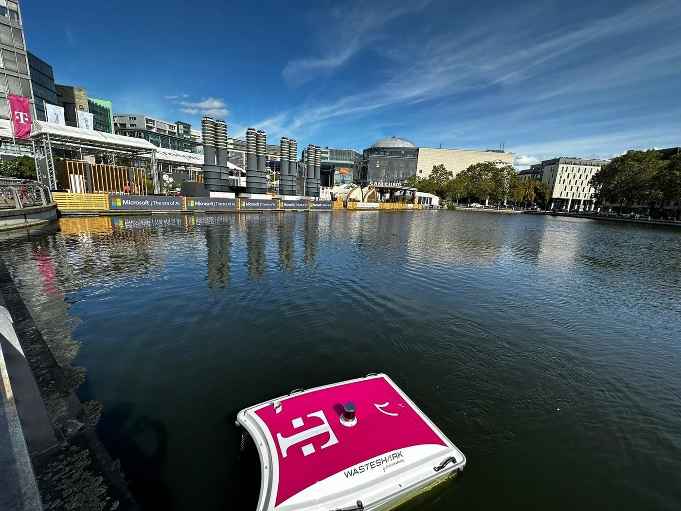A T-Mobile branded WasteShark drone on a city waterway during a technology conference.