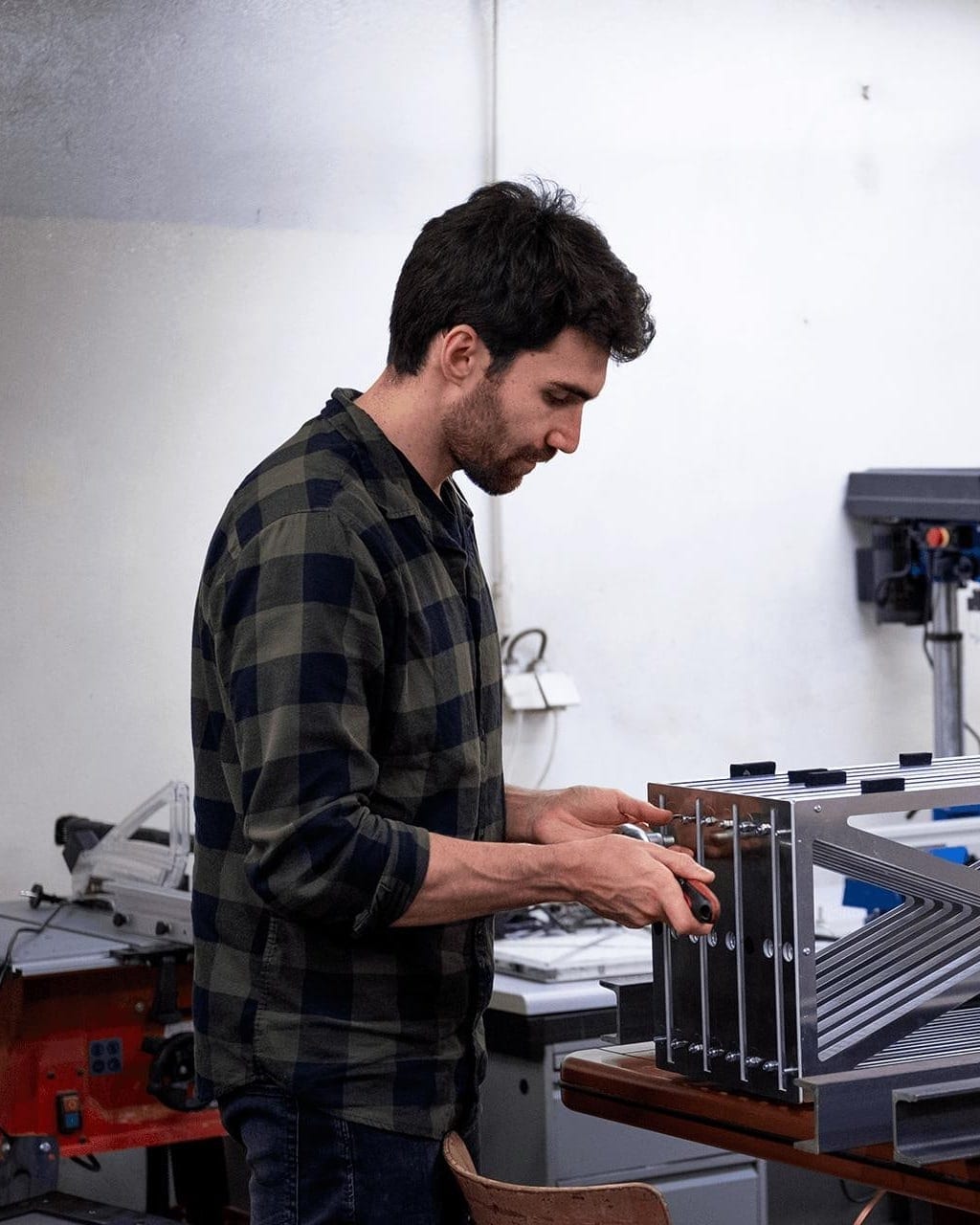 Two engineers assembling an aluminum heat-exchanger frame in a workshop